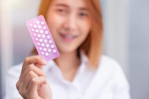 teen girl holding birth control pills