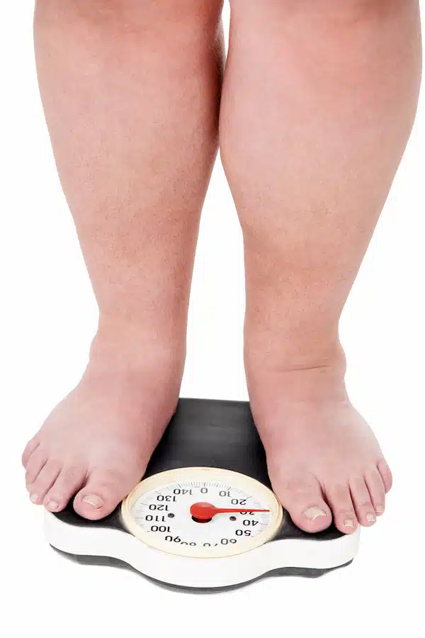 overweight woman weighing herself