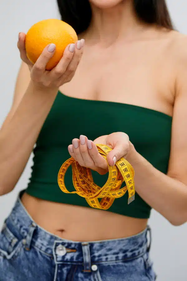 woman with orange and tape measure offering Personalized medical Weight Loss Plans