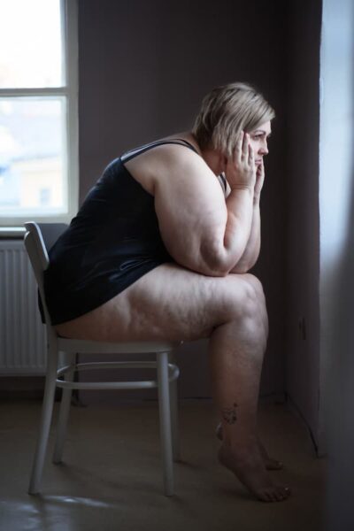 depressed obese woman looking out the window