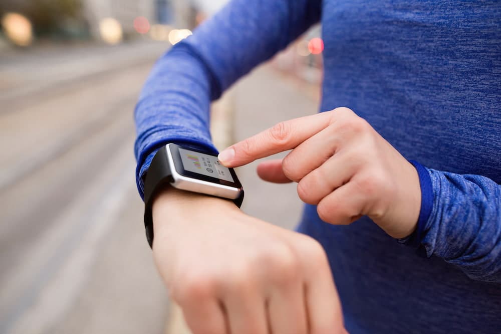 running woman using fitness band to track weightloss progress