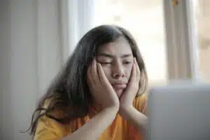 Melancholic woman watching video on laptop at home